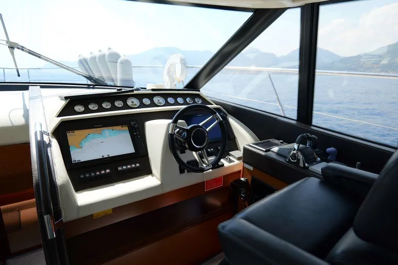 Grace Yacht Photos Pics Cockpit of 2013 Prestige 620 yacht with navigation system and steering wheel, overlooking the sea.