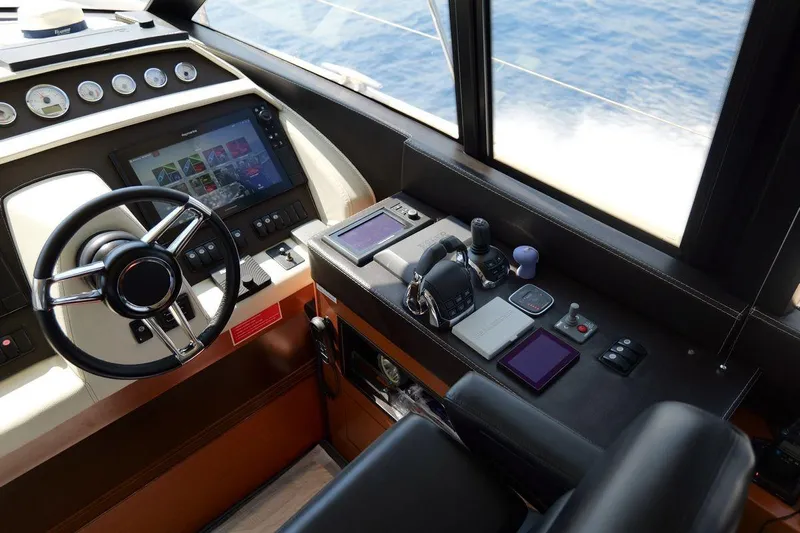 Grace Yacht Photos Pics Cockpit of 2013 Prestige 620 yacht with steering wheel and navigation controls.