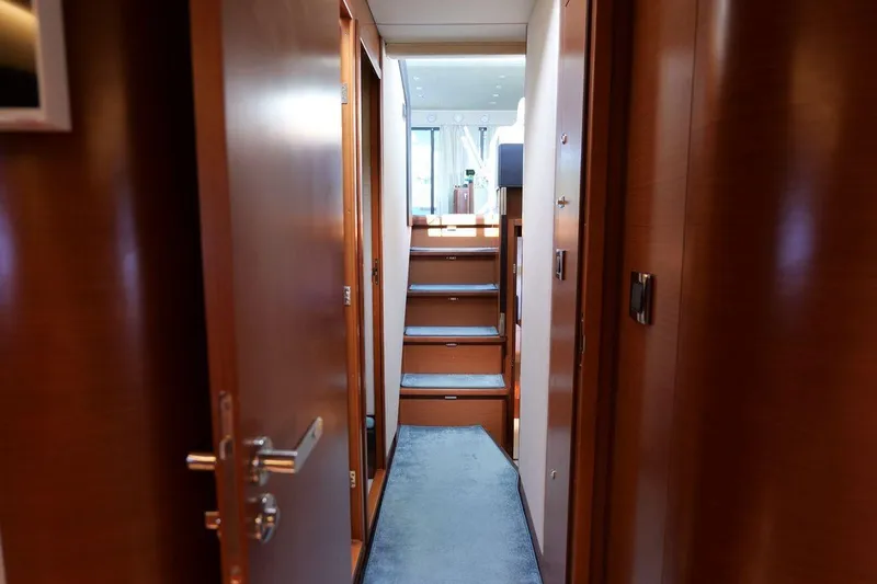 Grace Yacht Photos Pics Interior hallway of 2013 Prestige 620 yacht with wooden doors and carpeted stairs.