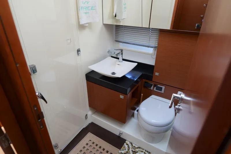 Grace Yacht Photos Pics Luxurious bathroom in 2013 Prestige 620 yacht with modern fixtures and wooden cabinetry.