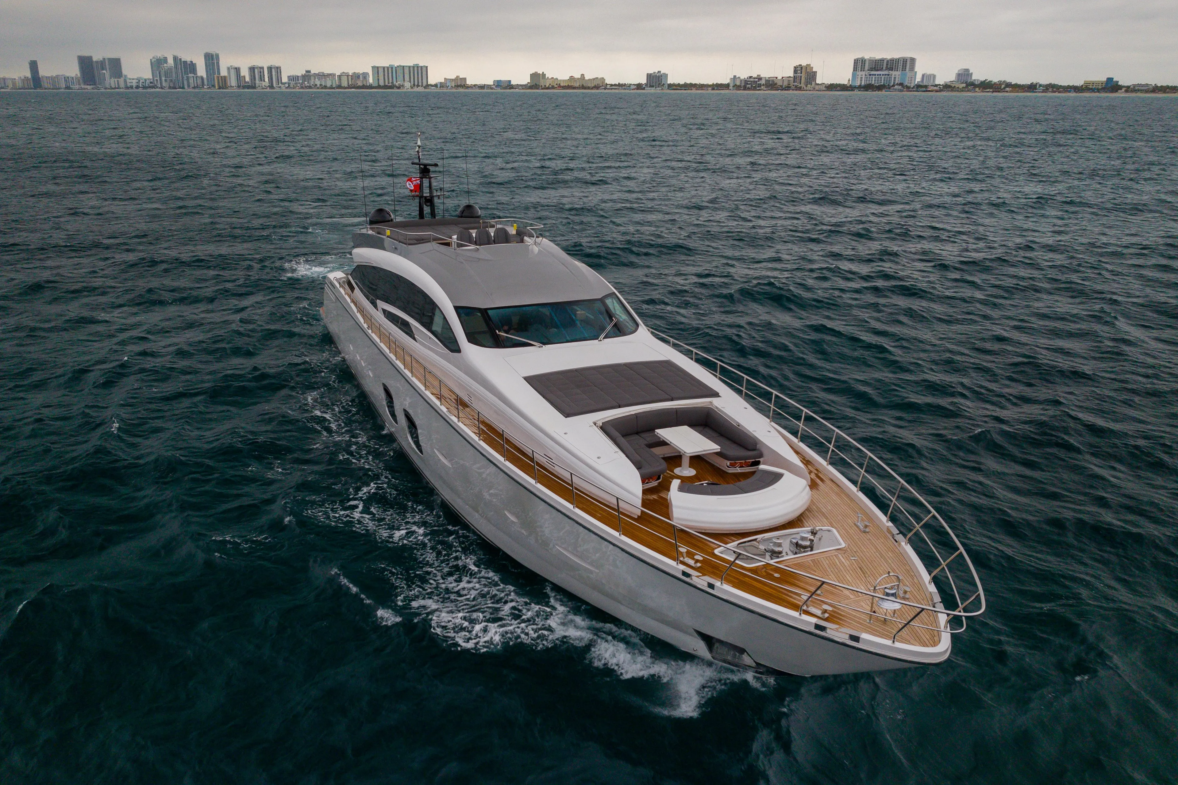 Luxury 2018 Pershing 108 yacht cruising on open water near city skyline.