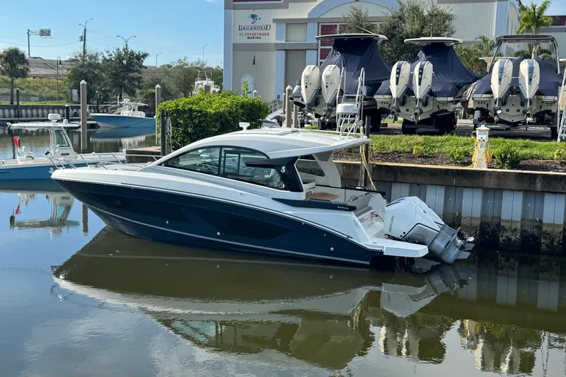  Yacht Photos Pics 2022 Beneteau Gran Turismo 32 yacht docked at marina, reflecting on calm water.