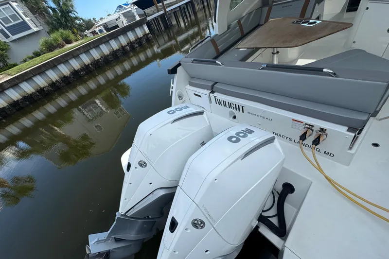  Yacht Photos Pics 2022 Beneteau Gran Turismo 32 with dual outboard engines docked by a canal.