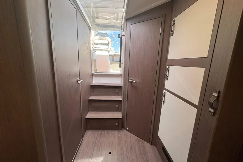  Yacht Photos Pics Interior of 2022 Beneteau Gran Turismo 32 yacht, featuring modern wood paneling and storage.