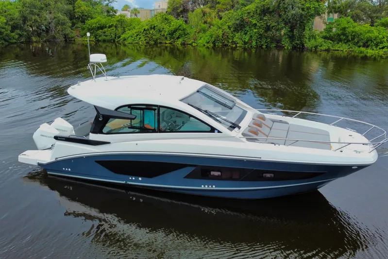  Yacht Photos Pics 2022 Beneteau Gran Turismo 32 yacht on a serene river, surrounded by lush greenery.