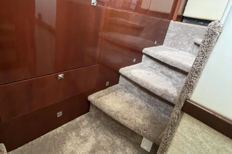 Cheri Pie Yacht Photos Pics Carpeted stairs inside 2008 Sea Ray 47 Sedan Bridge yacht with polished wood paneling.
