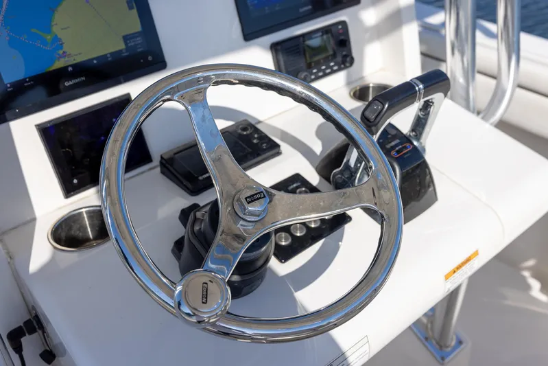  Yacht Photos Pics Steering wheel and controls of a 2018 Jupiter 26 FS boat cockpit.
