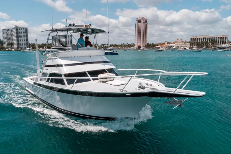 Shannon Yacht Photos Pics 1973 Striker 34 Canyon Runner yacht cruising in clear blue waters near coastal buildings.