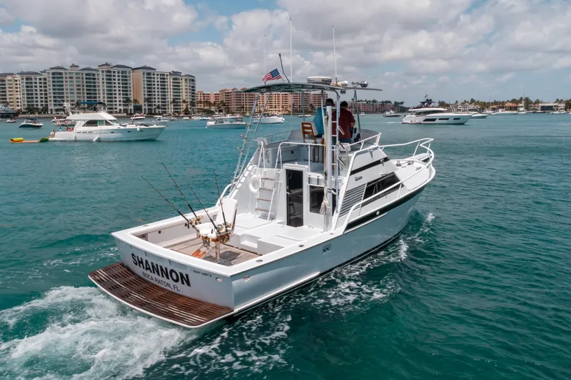 Shannon Yacht Photos Pics 1973 Striker 34 Canyon Runner boat cruising in a marina with cityscape background.