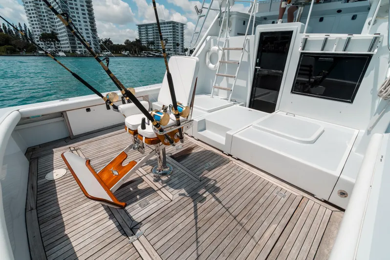Shannon Yacht Photos Pics 1973 Striker 34 Canyon Runner fishing boat deck with rods, wooden chair, and waterfront view.