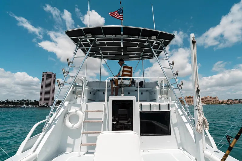 Shannon Yacht Photos Pics 1973 Striker 34 Canyon Runner boat on water, with person at helm, American flag flying.
