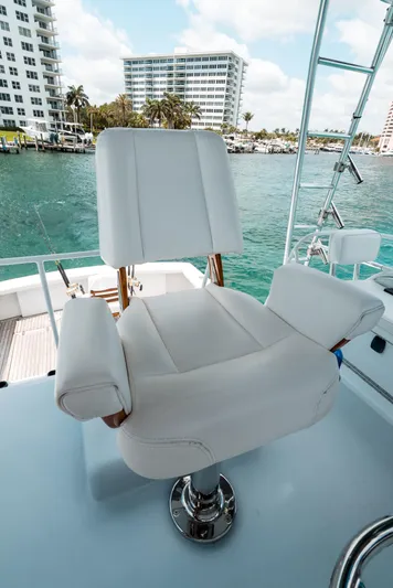Shannon Yacht Photos Pics Captain's chair on 1973 Striker 34 Canyon Runner yacht, overlooking marina and waterfront buildings.