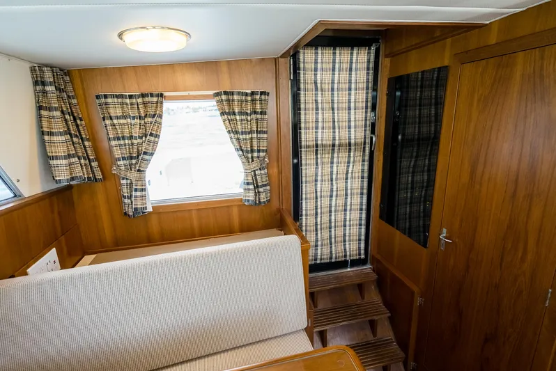 Shannon Yacht Photos Pics 1973 Striker 34 Canyon Runner interior with wood paneling and plaid curtains.