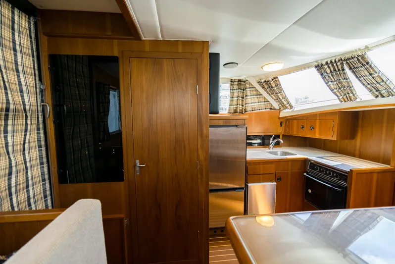 Shannon Yacht Photos Pics Interior of a 1973 Striker 34 Canyon Runner boat with wood paneling and kitchen amenities.