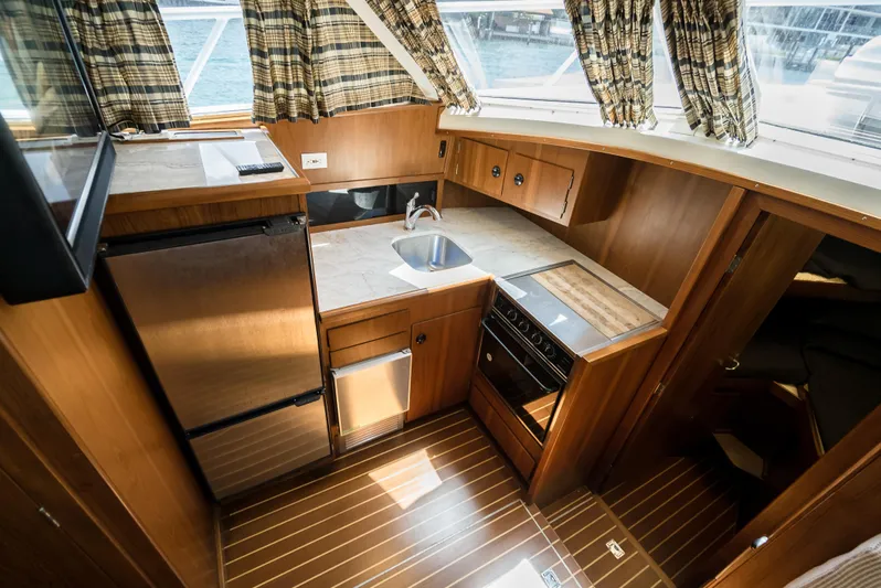 Shannon Yacht Photos Pics 1973 Striker 34 Canyon Runner yacht kitchen with wood finish, stainless appliances, and natural light.