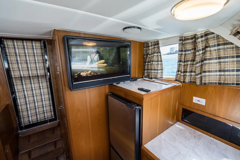 Shannon Yacht Photos Pics Interior of 1973 Striker 34 Canyon Runner boat with wood paneling and plaid curtains.