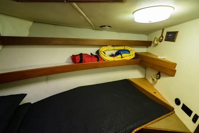 Shannon Yacht Photos Pics 1973 Striker 34 Canyon Runner cabin with bed, shelves, and nautical equipment.