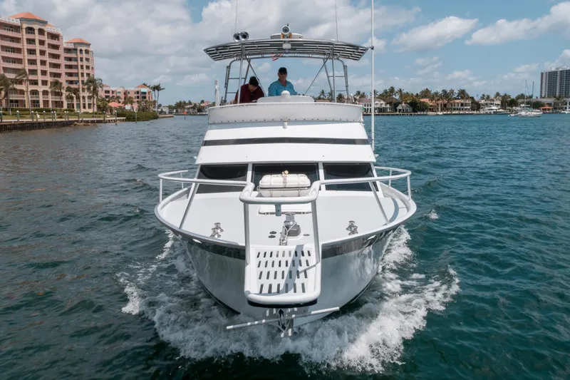 Shannon Yacht Photos Pics 1973 Striker 34 Canyon Runner boat cruising on a sunny day near coastal buildings.