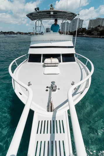 Shannon Yacht Photos Pics 1973 Striker 34 Canyon Runner boat on clear water, with city skyline in background.