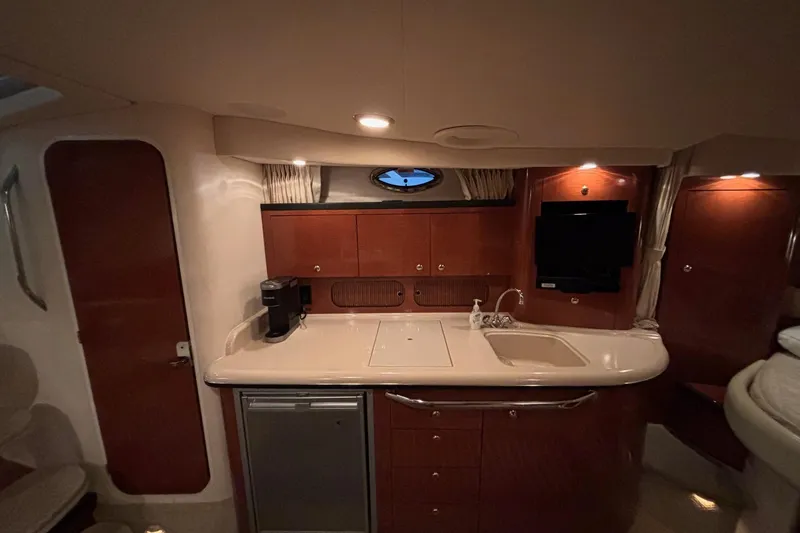 Dulce Vita Yacht Photos Pics 2003 Sea Ray 340 Sundancer cabin interior with kitchenette, sink, and TV.