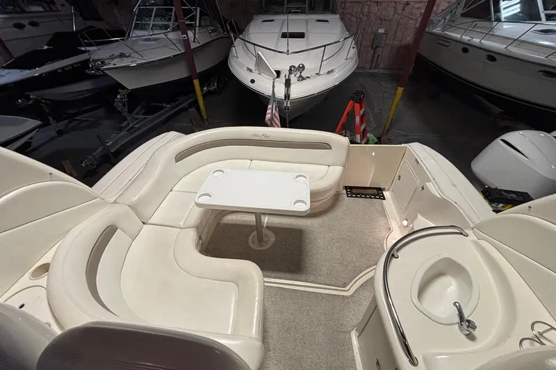 Dulce Vita Yacht Photos Pics 2003 Sea Ray 340 Sundancer interior with seating and table in a boat storage area.