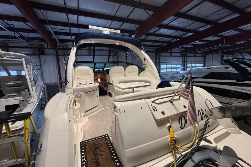 Dulce Vita Yacht Photos Pics 2003 Sea Ray 340 Sundancer yacht in indoor storage, featuring spacious seating and American flag.