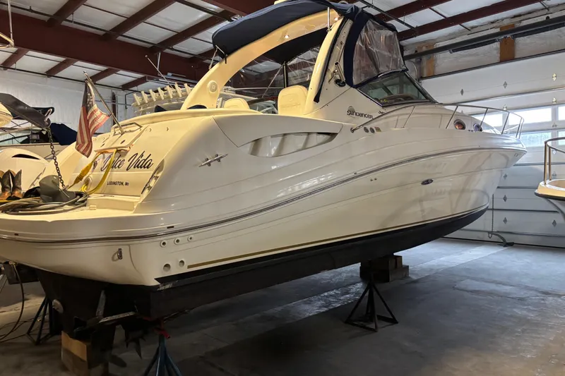 Dulce Vita Yacht Photos Pics 2003 Sea Ray 340 Sundancer yacht in indoor storage, featuring sleek design and American flag.