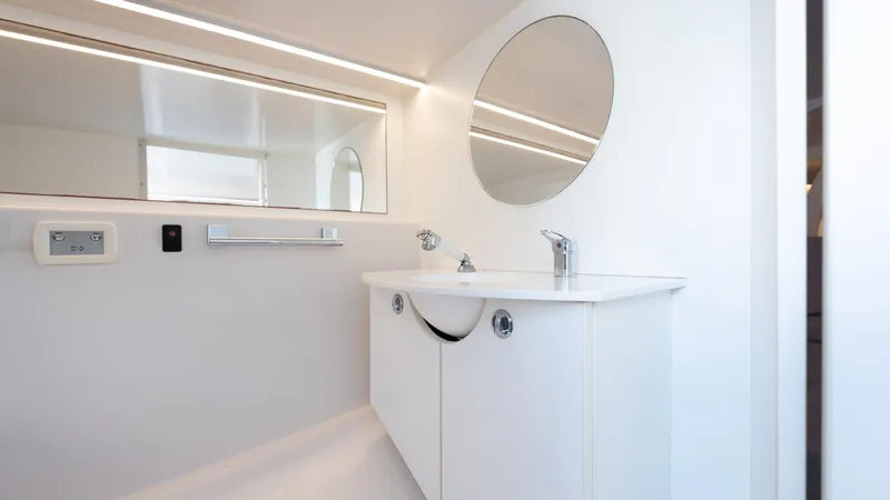 1017gt2017 Yacht Photos Pics Modern bathroom interior on 2017 Frauscher 1017 GT yacht, featuring sleek white design and round mirror.