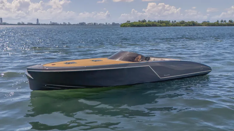 1017gt2017 Yacht Photos Pics 2017 Frauscher 1017 GT luxury boat on calm water, city skyline in background.