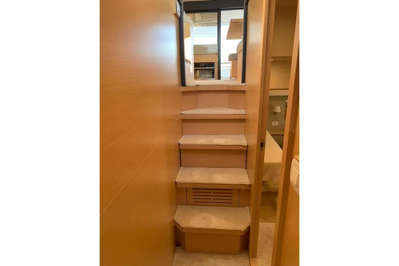  Yacht Photos Pics Interior stairs of 2022 Greenline 45 Coupe yacht, featuring wooden finish and carpeted steps.