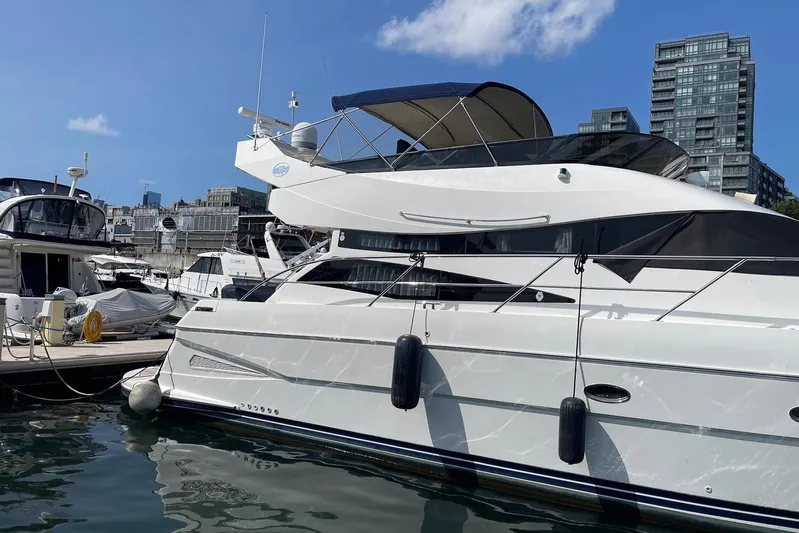 Passe Ports V Yacht Photos Pics 2004 Neptunus 56 Flybridge yacht docked in a marina with cityscape background.