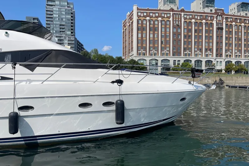 Passe Ports V Yacht Photos Pics 2004 Neptunus 56 Flybridge yacht docked near urban waterfront buildings.