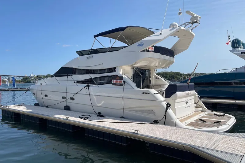 Passe Ports V Yacht Photos Pics 2004 Neptunus 56 Flybridge yacht docked at marina, sunny day.