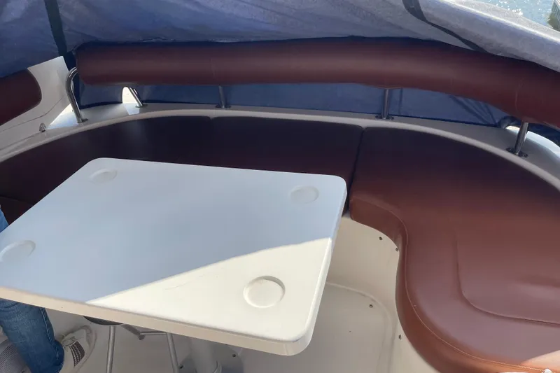 Passe Ports V Yacht Photos Pics 2004 Neptunus 56 Flybridge yacht interior with brown seating and white table.