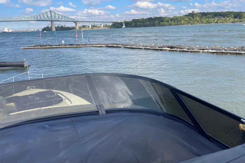 Passe Ports V Yacht Photos Pics 2004 Neptunus 56 Flybridge yacht on water with bridge and scenic background.