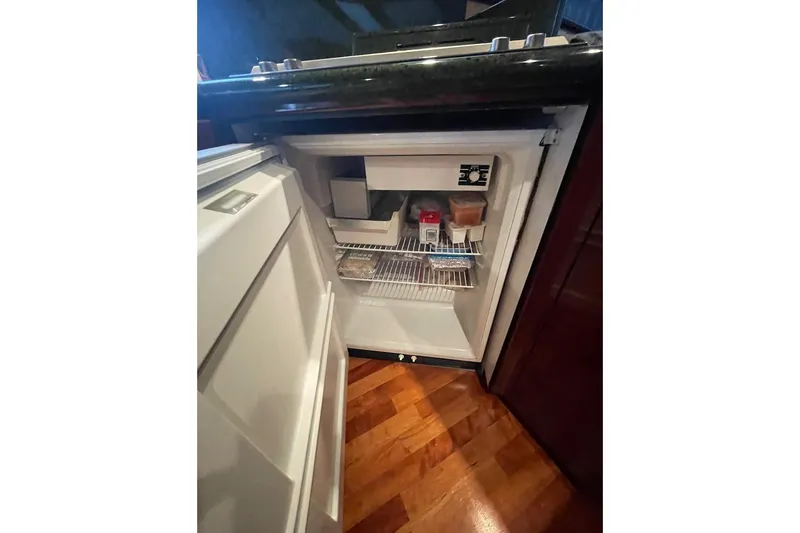 Passe Ports V Yacht Photos Pics Open refrigerator in 2004 Neptunus 56 Flybridge yacht kitchen, showing interior contents.