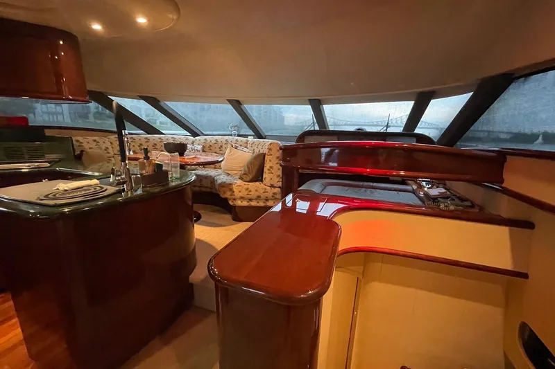 Passe Ports V Yacht Photos Pics Luxurious interior of 2004 Neptunus 56 Flybridge yacht with elegant seating and polished wood finishes.