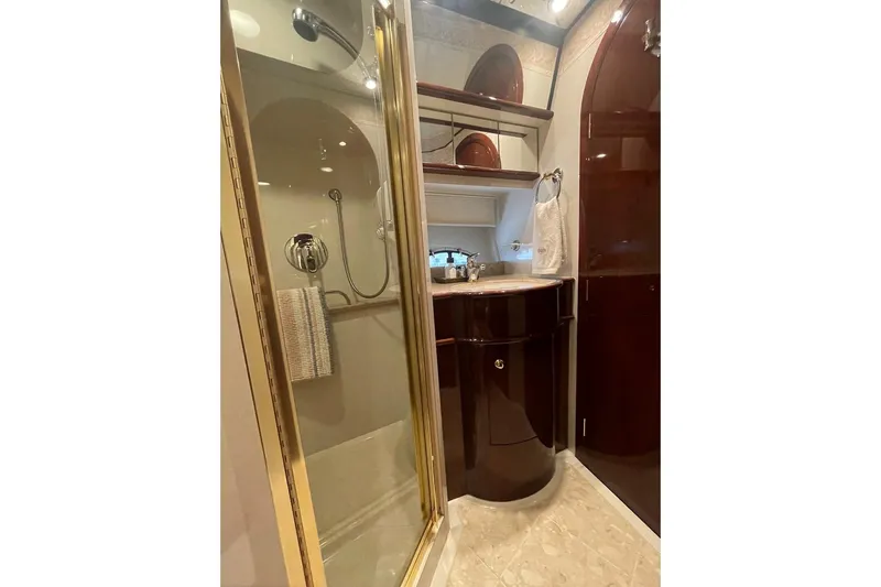 Passe Ports V Yacht Photos Pics Luxurious bathroom in 2004 Neptunus 56 Flybridge yacht with glass shower and elegant wood finishes.
