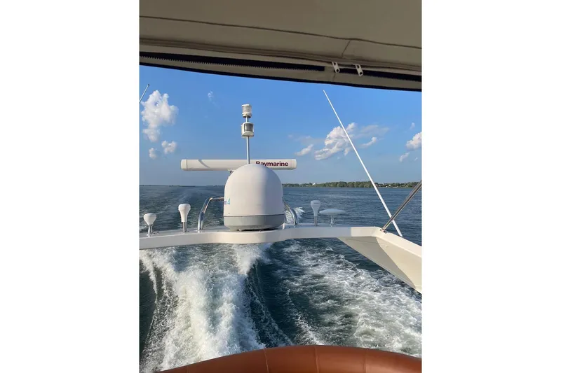 Passe Ports V Yacht Photos Pics 2004 Neptunus 56 Flybridge cruising on open water under clear blue skies.