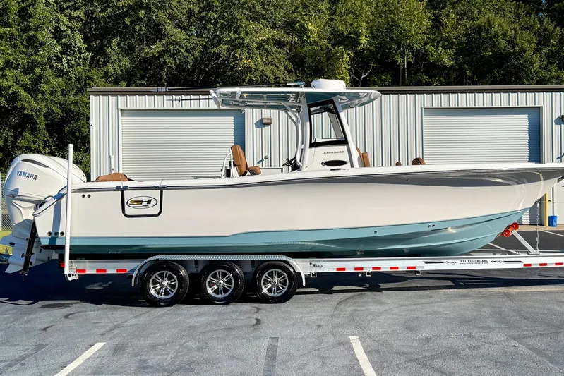  Yacht Photos Pics 2025 Sea Hunt Ultra 305 SE boat on trailer, parked outdoors near a building.
