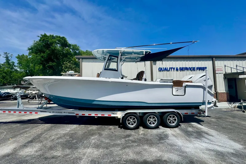  Yacht Photos Pics 2025 Sea Hunt Ultra 305 SE boat on trailer, parked outside service center.
