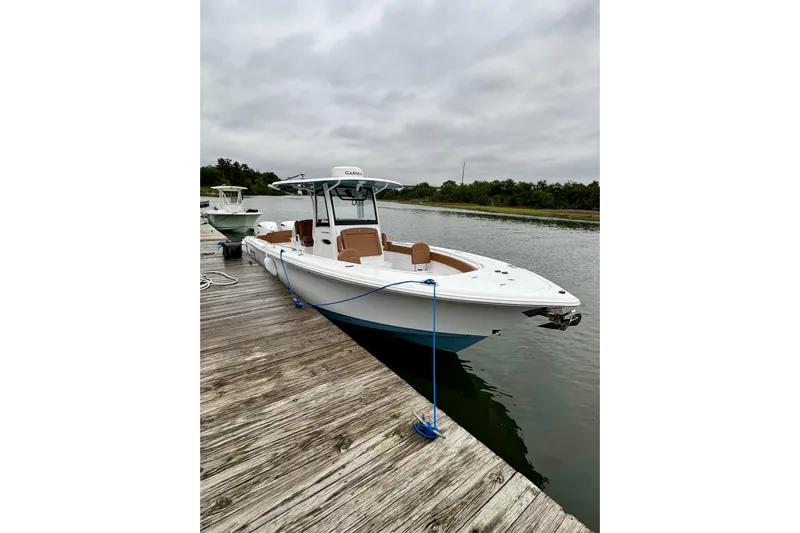  Yacht Photos Pics 2025 Sea Hunt Ultra 305 SE boat docked on a calm waterway.
