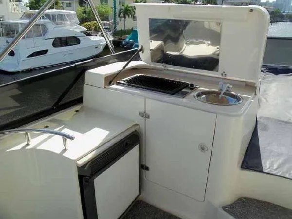 Passe Ports V Yacht Photos Pics Outdoor kitchenette on 2004 Neptunus 56 Flybridge yacht with grill and sink.