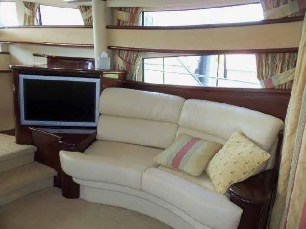 Passe Ports V Yacht Photos Pics Luxurious interior of 2004 Neptunus 56 Flybridge yacht with cream leather sofa and TV.