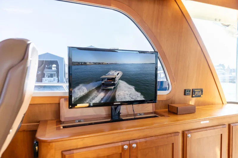 Jackson Yacht Photos Pics Interior of 2013 Sabre 38 Salon Express with TV displaying a boat on water.