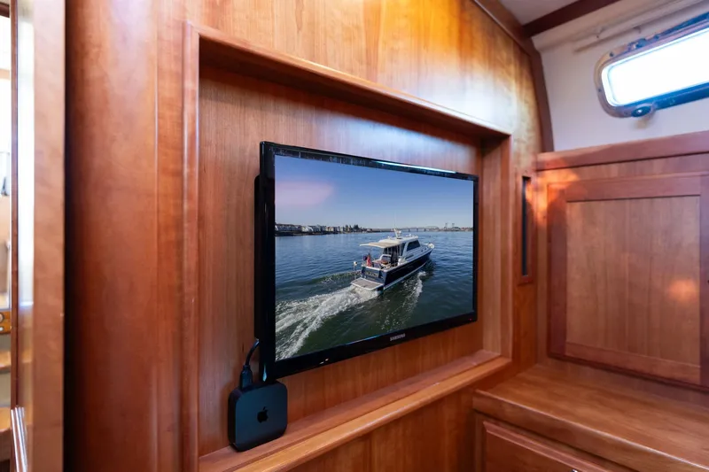 Jackson Yacht Photos Pics Interior of 2013 Sabre 38 Salon Express with TV displaying a boat on water.