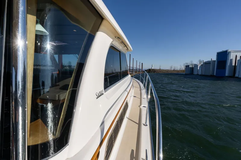 Jackson Yacht Photos Pics 2013 Sabre 38 Salon Express yacht on water, sunny day, marina in background.