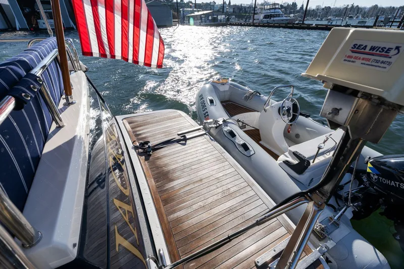 Jackson Yacht Photos Pics 2013 Sabre 38 Salon Express yacht with American flag and attached dinghy on water.