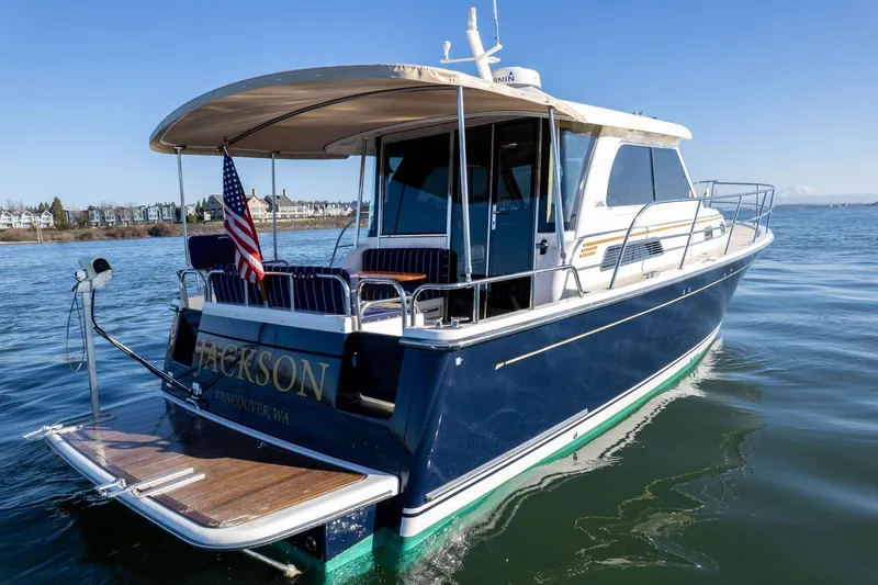 Jackson Yacht Photos Pics 2013 Sabre 38 Salon Express yacht on calm water, rear view with American flag.