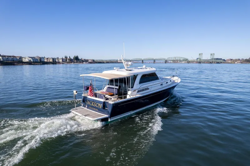 Jackson Yacht Photos Pics 2013 Sabre 38 Salon Express yacht cruising on a calm river with a bridge in the background.